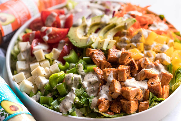 Buffalo Chicken Salad made with Primal Kitchen Buffalo Sauce and Ranch, in a white bowl.