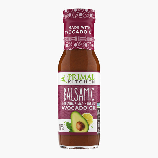 A bottle of Primal Kitchen Balsamic Dressing and Marinade made with avocado oil, with a wine colored label, on a light grey background. 