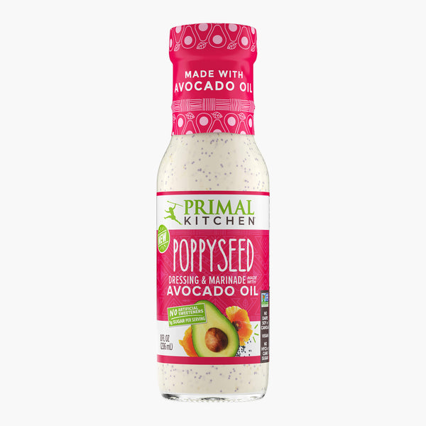 A bottle of creamy Primal Kitchen Poppyseed Dressing & Marinade made with avocado oil and no artificial sweeteners, with a pink-red label, on a light grey background.