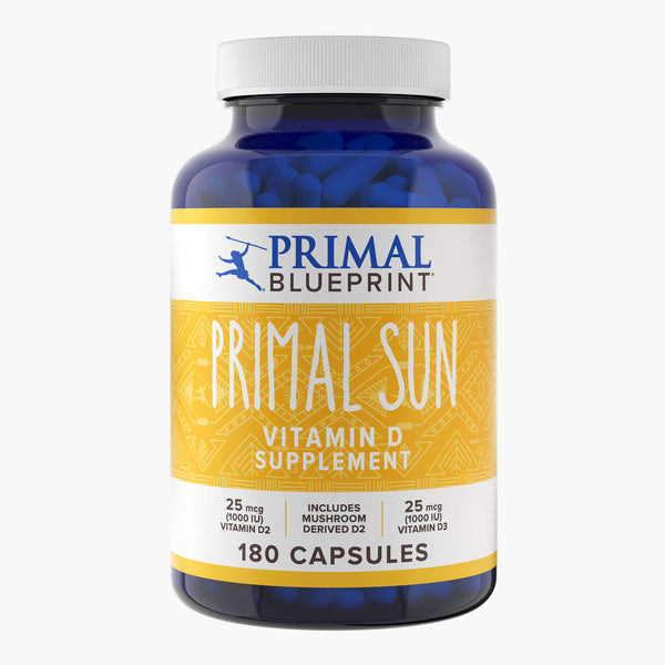 A blue bottle of Primal Blueprint Primal Sun with a yellow label against a white background.