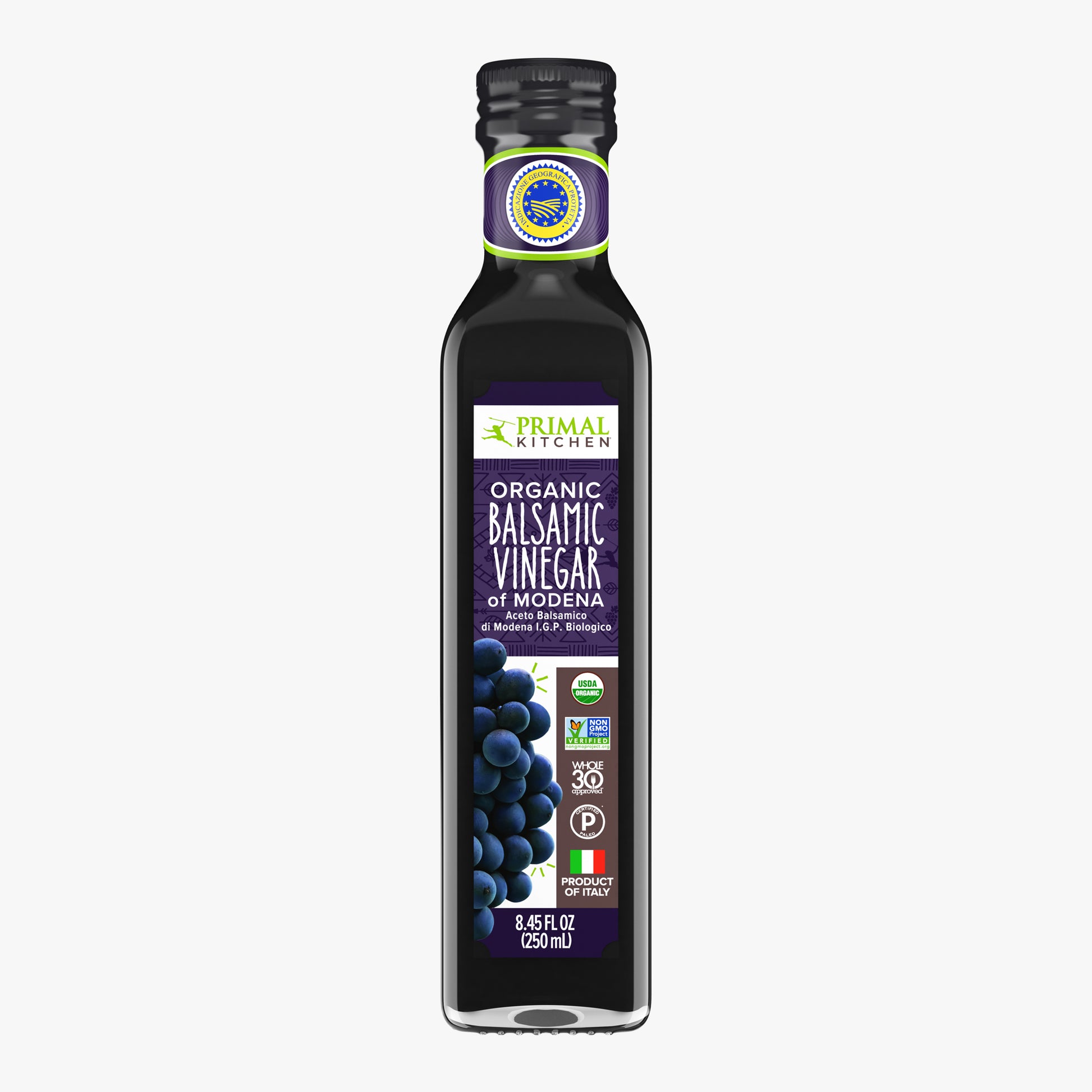 A bottle of Primal Kitchen Organic Balsamic Vinegar of Modena with a dark purple label on a light grey background.