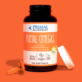 A blue bottle of Primal Blueprint Primal Omegas with an orange and white label on an orange background.