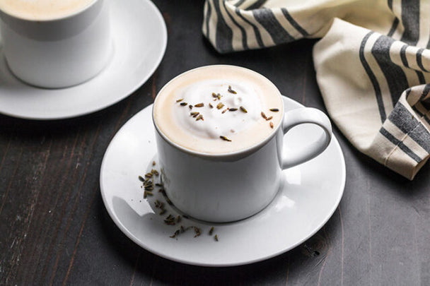 Mug of frothy London Fog drink sprinkled with dried lavender buds. 
