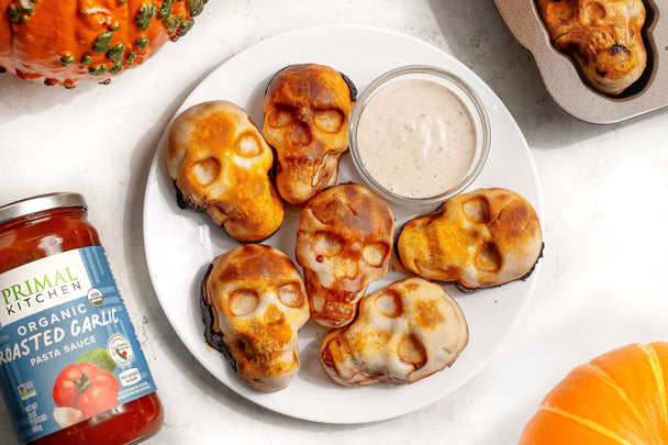 Pizza skulls on a plate with Ranch Dressing for dipping and a jar of Primal Kitchen Organic Roasted Garlic Marinara