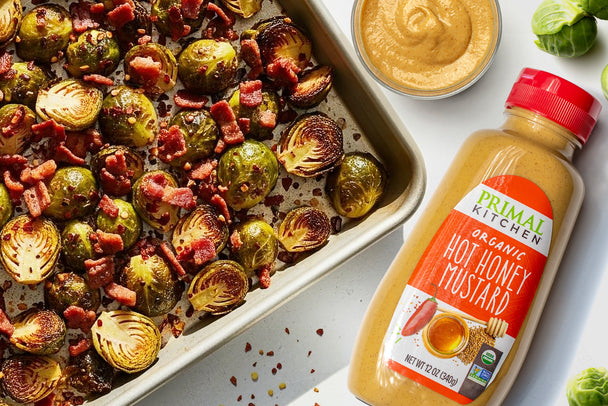 Tray of roasted Brussels sprouts with Primal Kitchen Hot Honey Mustard. 