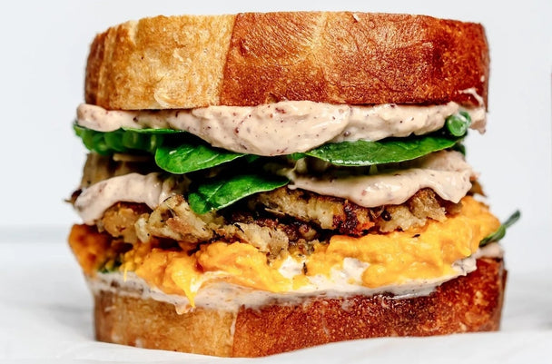 A leftover turkey sandwich next to a jar of Primal Kitchen Cranberry Mayo. 