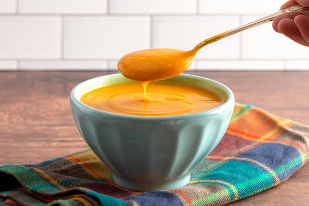 Bowl of sweet potato butternut squash soup in a blue ceramic bowl.