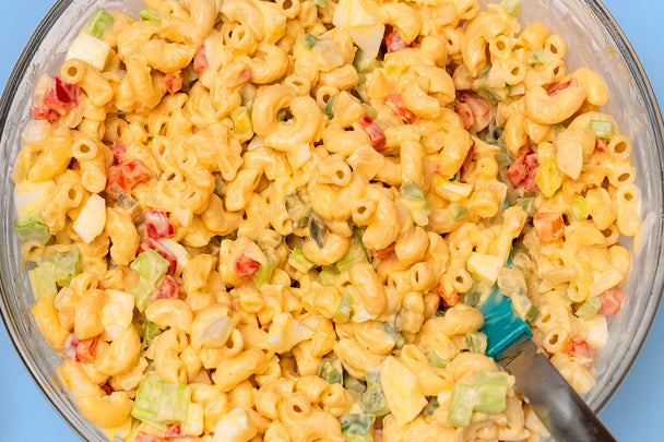 Overhead shot of a bowl of macaroni salad made with chickpea elbows, eggs, veggies, and Primal Kitchen Mayo.