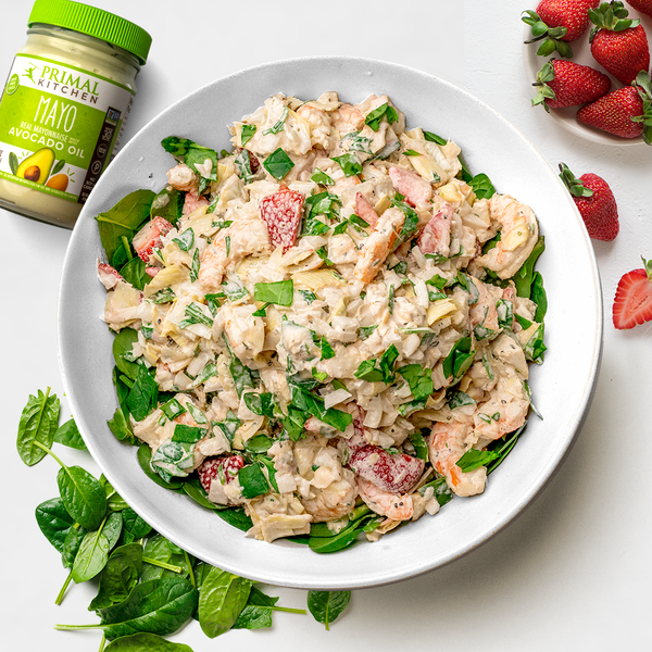 A bowl of Creamy Shrimp Salad with Mayo surrounded by Primal Kitchen Mayo with Avocado Oil, spinach and strawberries.