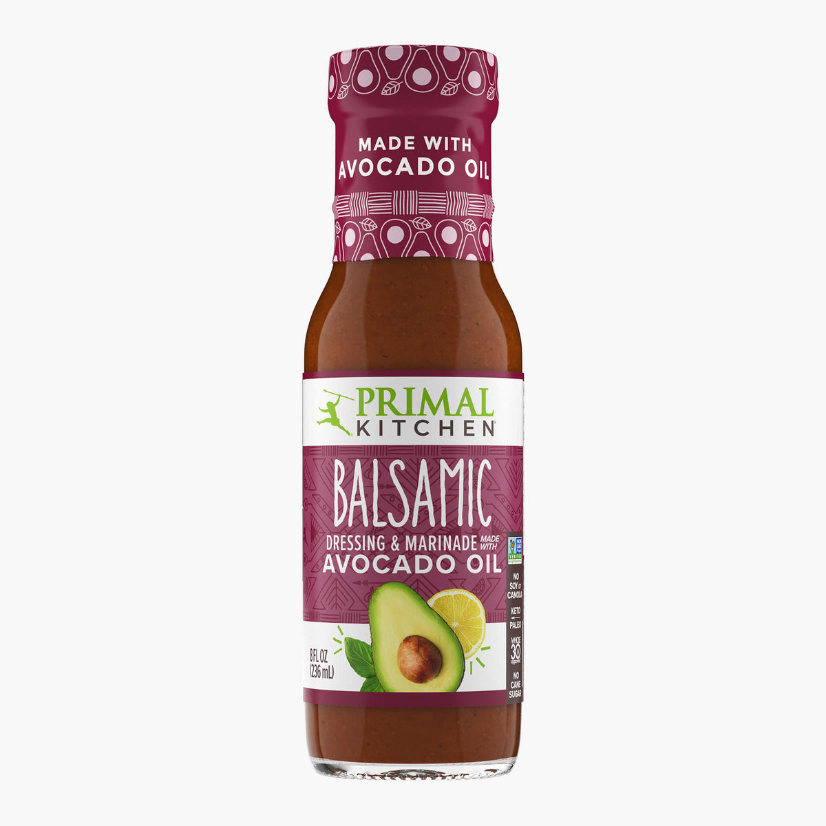 A bottle of Primal Kitchen Balsamic Dressing and Marinade made with avocado oil, with a wine colored label, on a light grey background. 