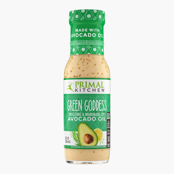 A bottle of Primal Kitchen Green Goddess Dressing & Marinade made with avocado oil, with a green label, on a light grey background.