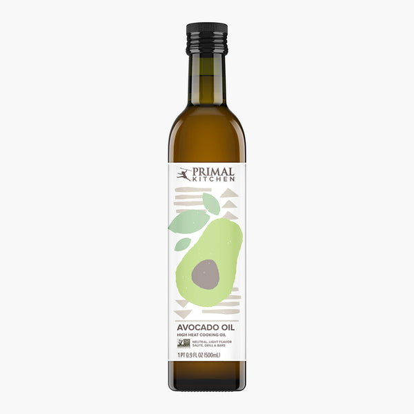 A 500mL dark brown glass bottle with Primal Kitchen Avocado Oil displaying an illustrated avocado cut open.