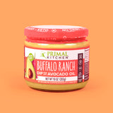 Front of a jar of Primal Kitchen Buffalo Ranch Dip made with avocado oil, on an orange background.