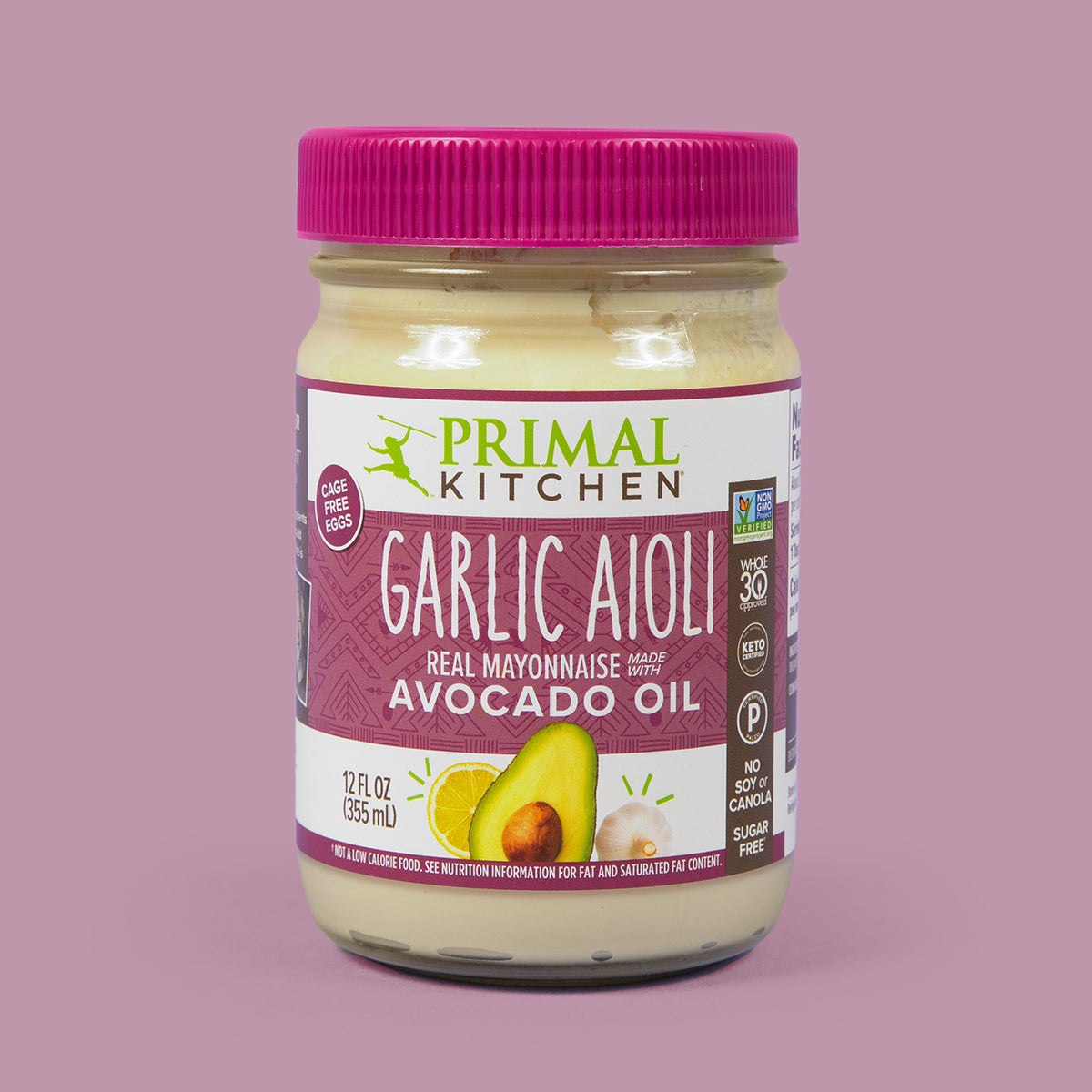 A jar of Primal Kitchen Garlic Aioli Mayo made with Avocado Oil with a purple label and lid on a light pink background.