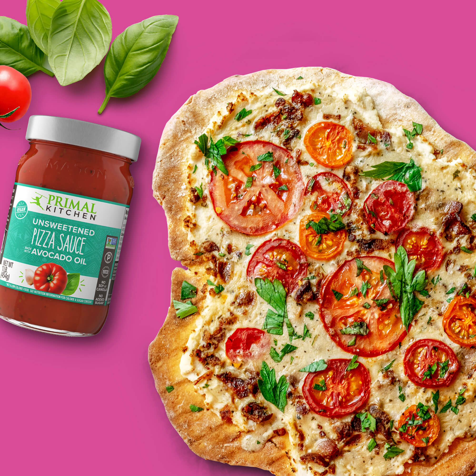 A delicious tomato cheese flatbread pizza  next to a jar of Primal Kitchen Unsweetened Red Pizza Sauce and basil leaves on a bright pink background.  