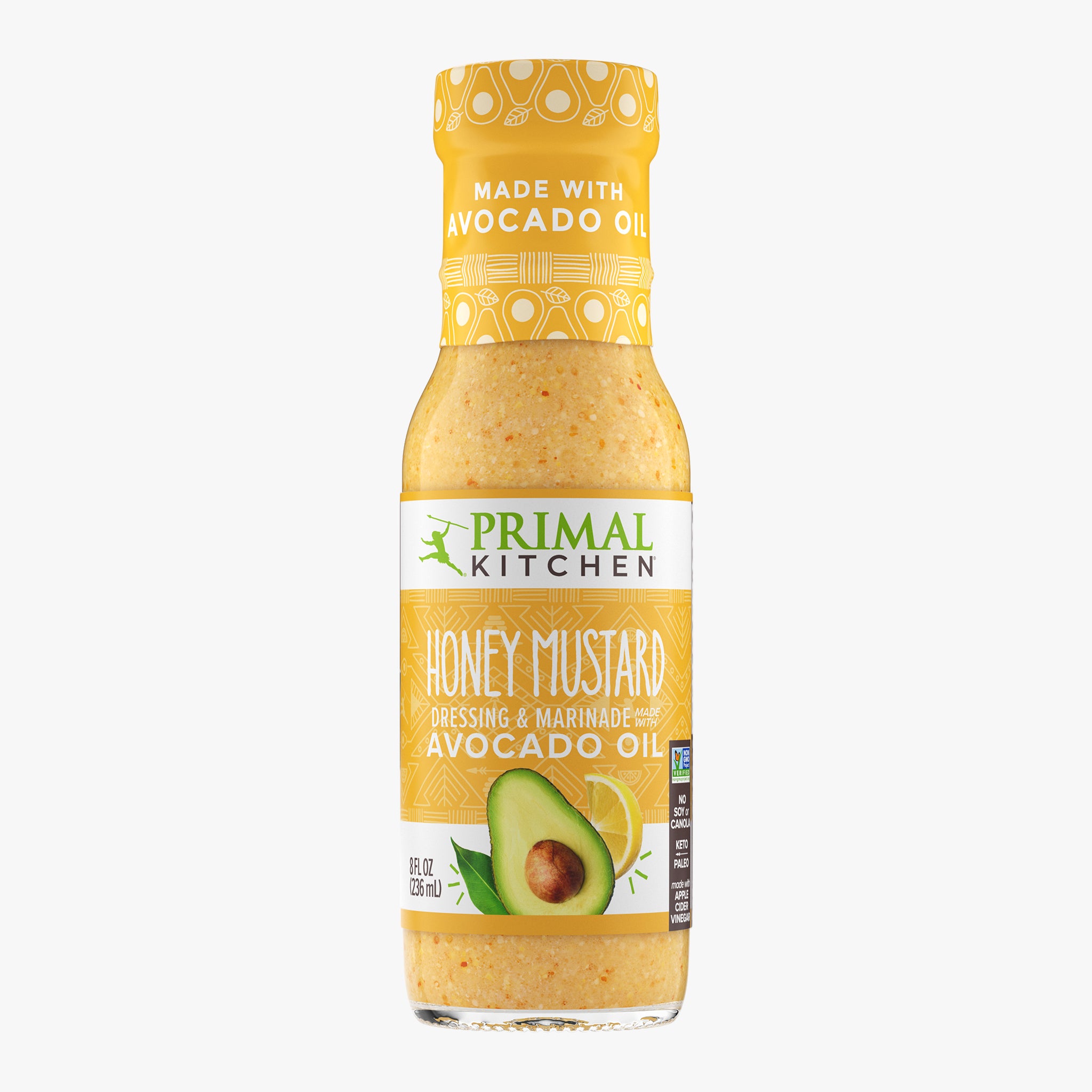 A bottle of Primal Kitchen Honey Mustard Vinaigrette and Marinade made with avocado oil, with a yellow label, on a light grey background.